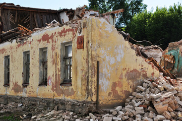 Old building. A dilapidated white brick building with a broken wooden roof.