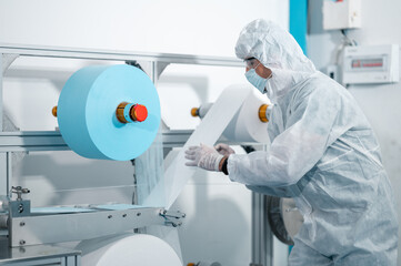 Scientists wearing uniform protection. Check the manufacturing process of face masks. In a laboratory at industry plants. The concept for security and protection coronavirus covid-19.