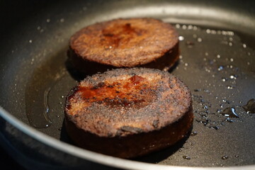 vegan plant-based burger patty being fried in pan with coconut oil