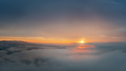 Fototapeta na wymiar sunrise high above the clouds with the sun