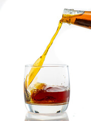pouring whiskey into a transparent glass on a white background