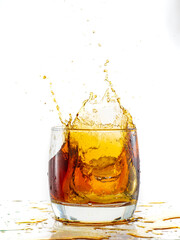 splash from falling ice glass with whiskey on white background