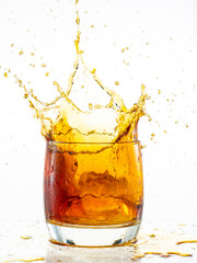 splash from falling ice glass with whiskey on white background