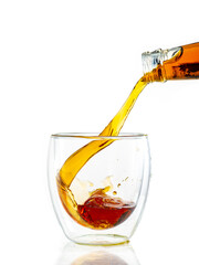 pouring whiskey into a transparent glass on a white background