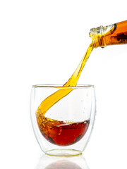 pouring whiskey into a transparent glass on a white background