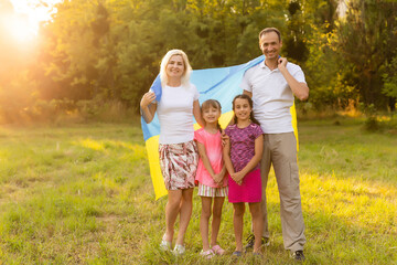 Fototapeta premium happy family with flag of ukraine in field. lifestyle