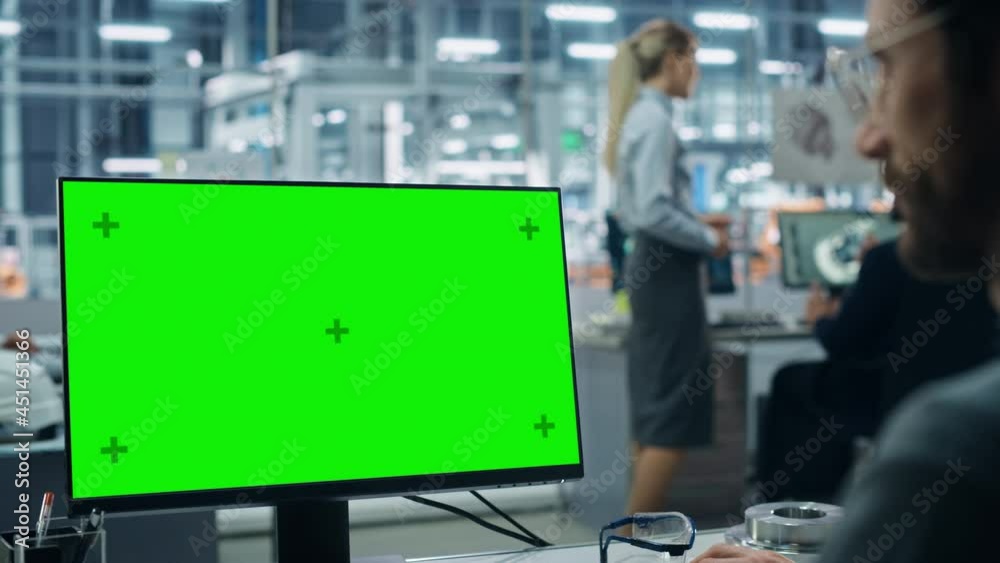 Poster car factory office: male automotive engineer sitting at his desk working on green screen chroma key 