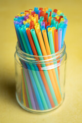 Fototapeta premium Pile of colorful plastic straws in a glass jar