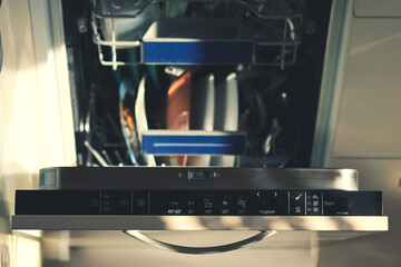 Open dishwasher with dishes inside for washing