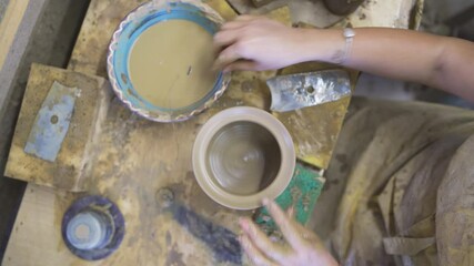 High angle view of female potter molding brown clay in pottery workshop