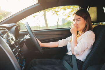 Young Asian woman holding her nose because of bad smell after turn on car air conditioning - obrazy, fototapety, plakaty