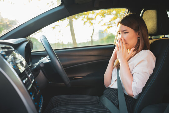 Young Asian woman holding her nose because of bad smell after turn on car air conditioning