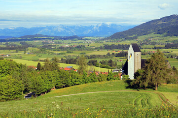 Die kleine Gemeinde Oy-Mittelberg in Bayern mit der katholischen Kirche vor den Allgäuer Alpen