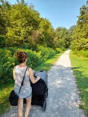 Giovane donna che passeggia con i suoi gemelli nel parco in estate