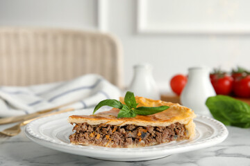 Piece of delicious pie with minced meat on table indoors