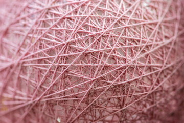Wicker texture. Close-up The ball is wrapped in pink threads. Cobweb tablecloth.