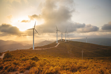 Eco energy. Wind turbine eco farm on beautiful blue orange golden hour summer evening mountain landscape. Renewable energy production for green ecological world. Wind farm eco field
