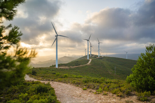 Eco energy. Wind turbine eco farm on beautiful blue orange golden hour summer evening mountain landscape. Renewable energy production for green ecological world. Wind farm eco field