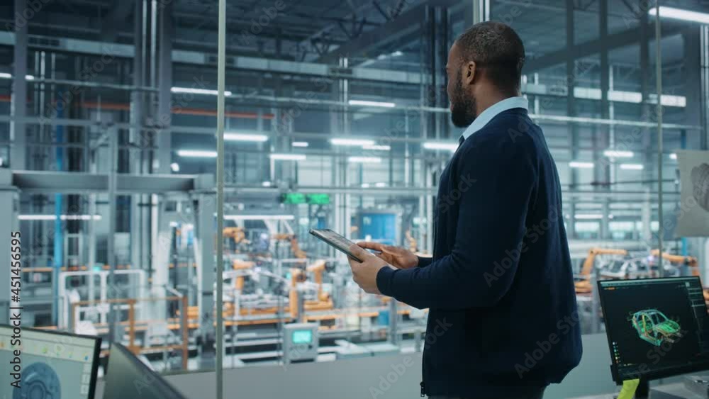 Poster car factory office: portrait of successful black male chief engineer using tablet computer in automa
