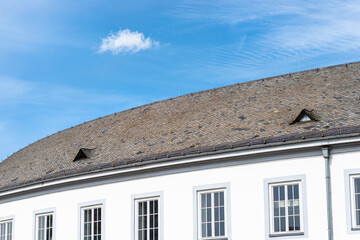 The Large round roof is covered with the flat tile of an old house with two triangular windows in the attic.