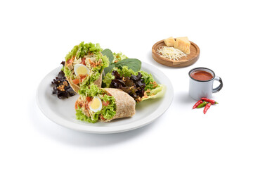Front view of quail egg and chicken wrap with salad and condiments aside, isolated