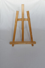 Wooden folding tabletop three-legged painting easel on white background