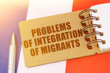 On the flag of France lies a notebook with the inscription - problems of integration of migrants