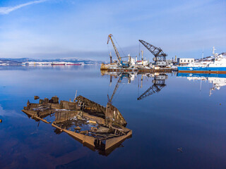 view of the docks in winter from the sea. rusty skeleton in the foreground.