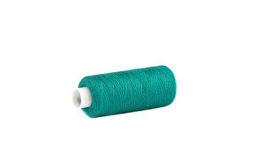 Spool of green thread lies on a white background.