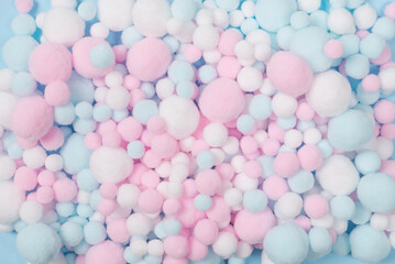 White, pink and blue soft pompons as a background.