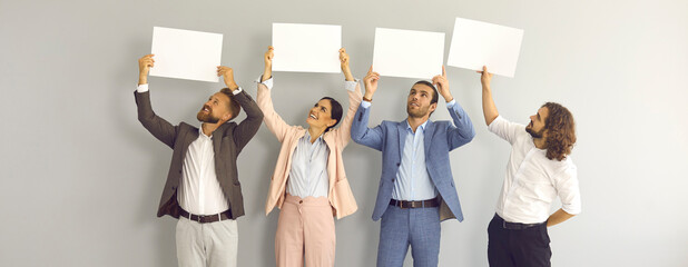 Team of positive people with paper banners sharing message or expressing opinion. Group of four...