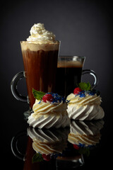 Small Pavlova desserts with raspberry, blueberry, and mint.