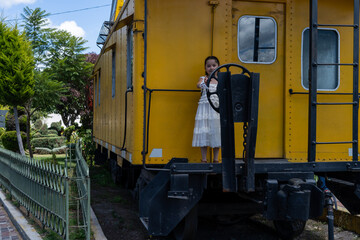 vestido beige tren niña vagón amarillo arboles