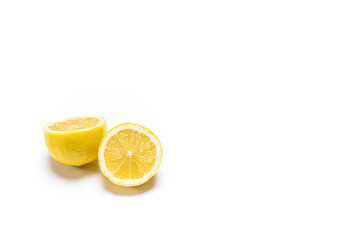 Photo of a lemon in two halves on a white background.The photo has copy space and is taken in horizontal format.