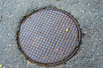 Obraz na płótnie Canvas Metallic manhole cover of the city sewerage close-up.