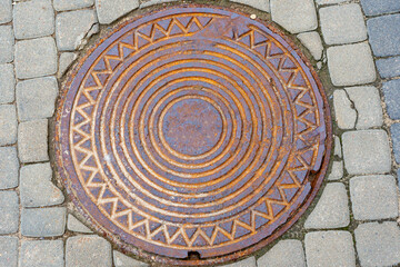 Metallic manhole cover of the city sewerage close-up.