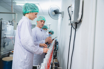 professional inspection control scientist in uniform are working for fruit juice production industry in food manufacturing factory, water drink checking and beverage research in laboratory