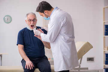Fototapeta premium Old male patient visiting young male doctor otorhinolaryngologis