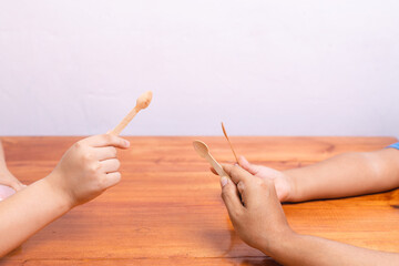 hands grabbing spoons on the table