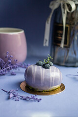 lavender cake on blue table with flowers and tea cup