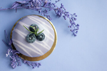 lavender cake on blue table with flowers