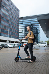 Sustainable mobility city transportation. Green sustainable transportation. Young man unlocks an e-scooter with his mobile phone. Electric scooter new eco way mobility. Climate neutral cities goals.