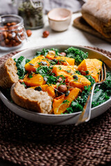 Season salad with grilled pumpkin, kale, chickpea, pepitas and nuts. Autumn vegetarian healthy recipe.