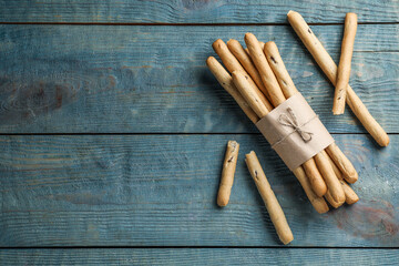 Delicious grissini sticks on wooden table, flat lay. Space for text