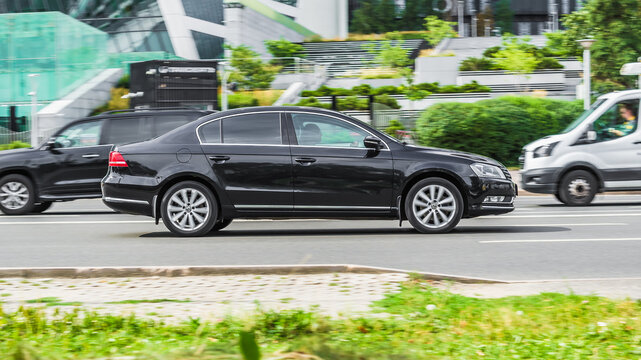 Black Volkswagen Passat B7 car seventh generation speed driving on asphalt city road at daytime