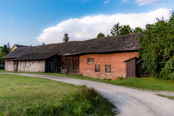 Fototapeta na wymiar Stara chata chałupa z cegły i drewna, dom z oborą
