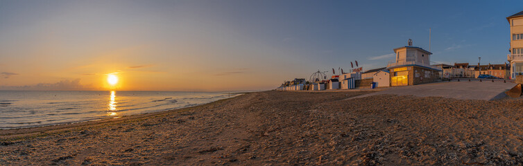 Fototapeta premium Langrune Sur Mer, France - 08 04 2020: Beach cabins on the beach at sunrise along the sea wall