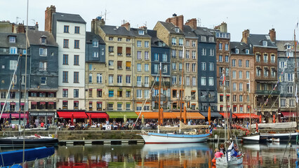 Honfleur, France - October 8. 2015: View on harbor promenade with typical breton old houses and boats