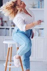 attractive plus size woman in motion, wearing high waist jeans and shirt