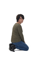 side view of a woman kneeling on white background looking at camera